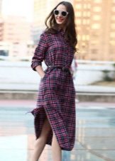 Ang naka-checkered na damit ng damit na may sinturon sa ibaba ng tuhod at may mga slits sa mga gilid