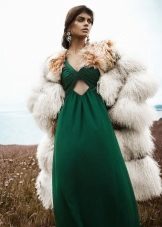 Maikling fur coat sa isang mahabang berdeng damit