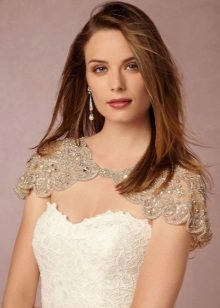 White wedding dress case sa kumbinasyon ng isang beige lace cape sa mga balikat