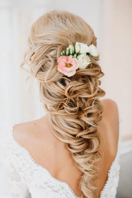 Mga sariwang bulaklak sa isang hairstyle ng kasal